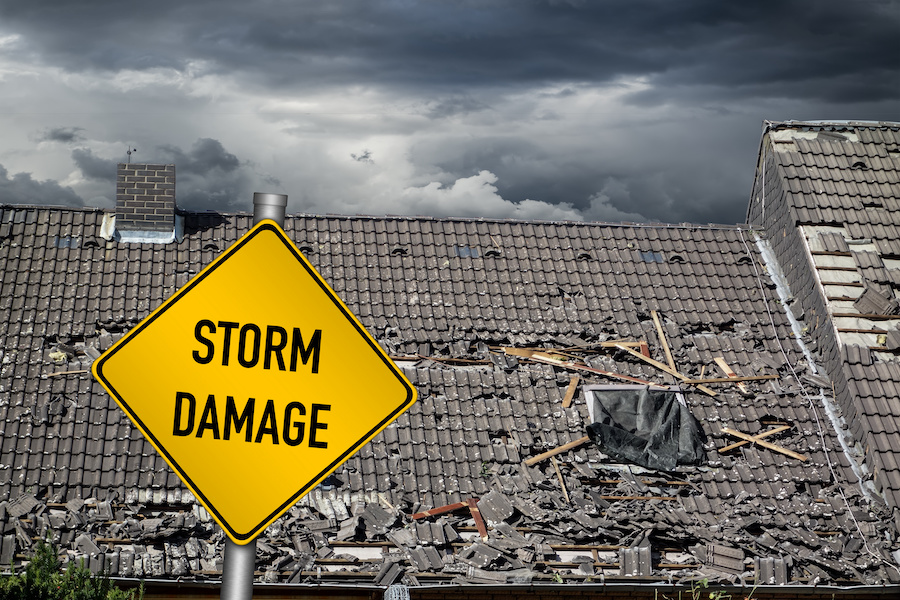 roof of house damaged by heavy hurricane tornado storm